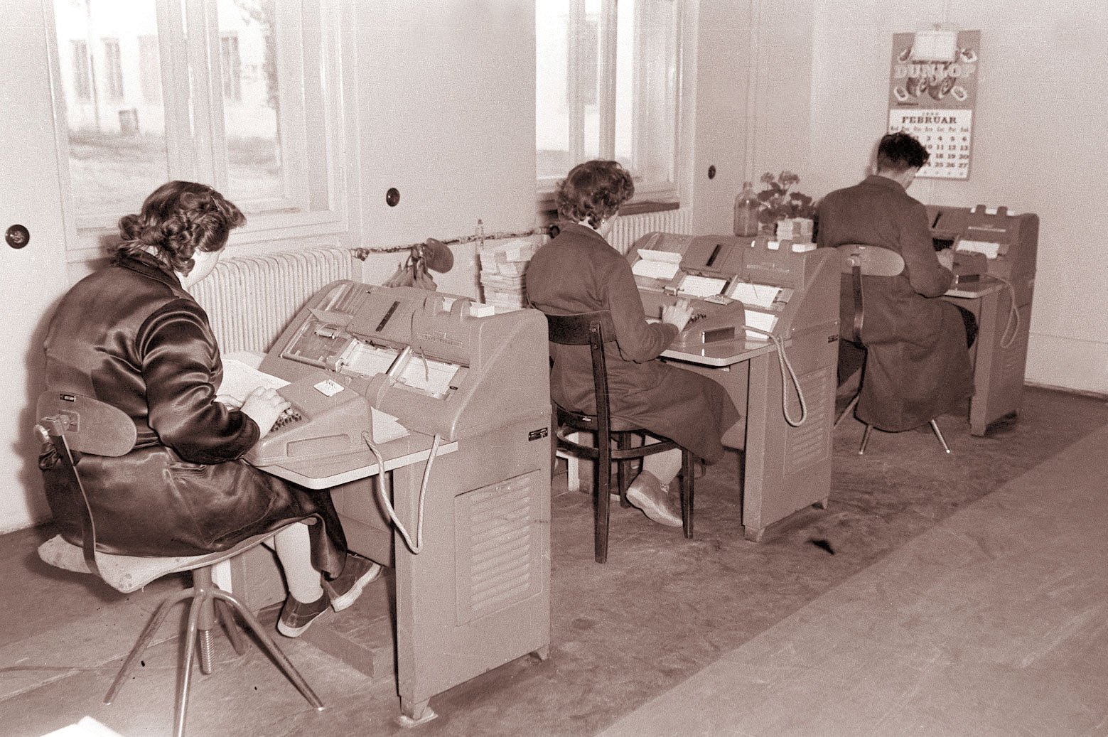 Three clerks working at automatic accounting machines in an office in 1960