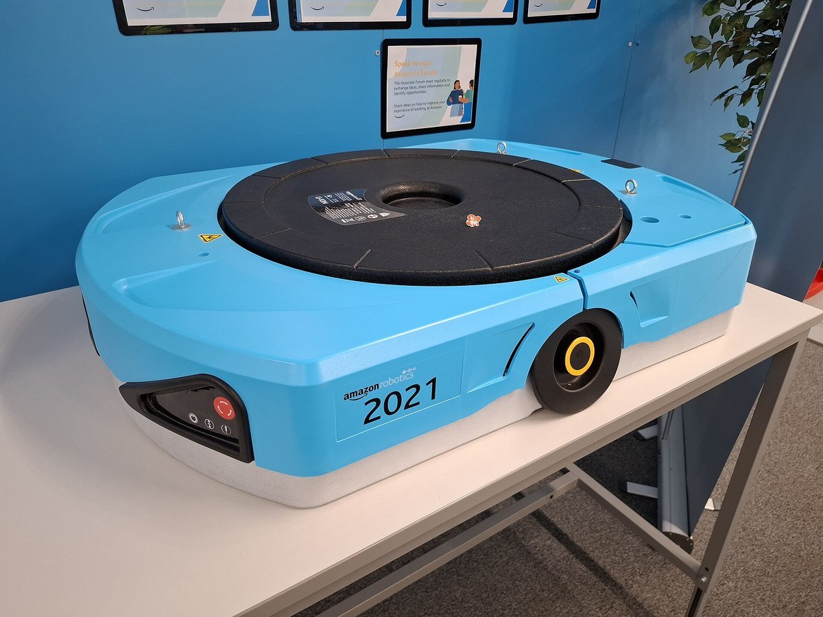A blue Amazon Robotics drive unit robot displayed on a table at a fulfilment centre