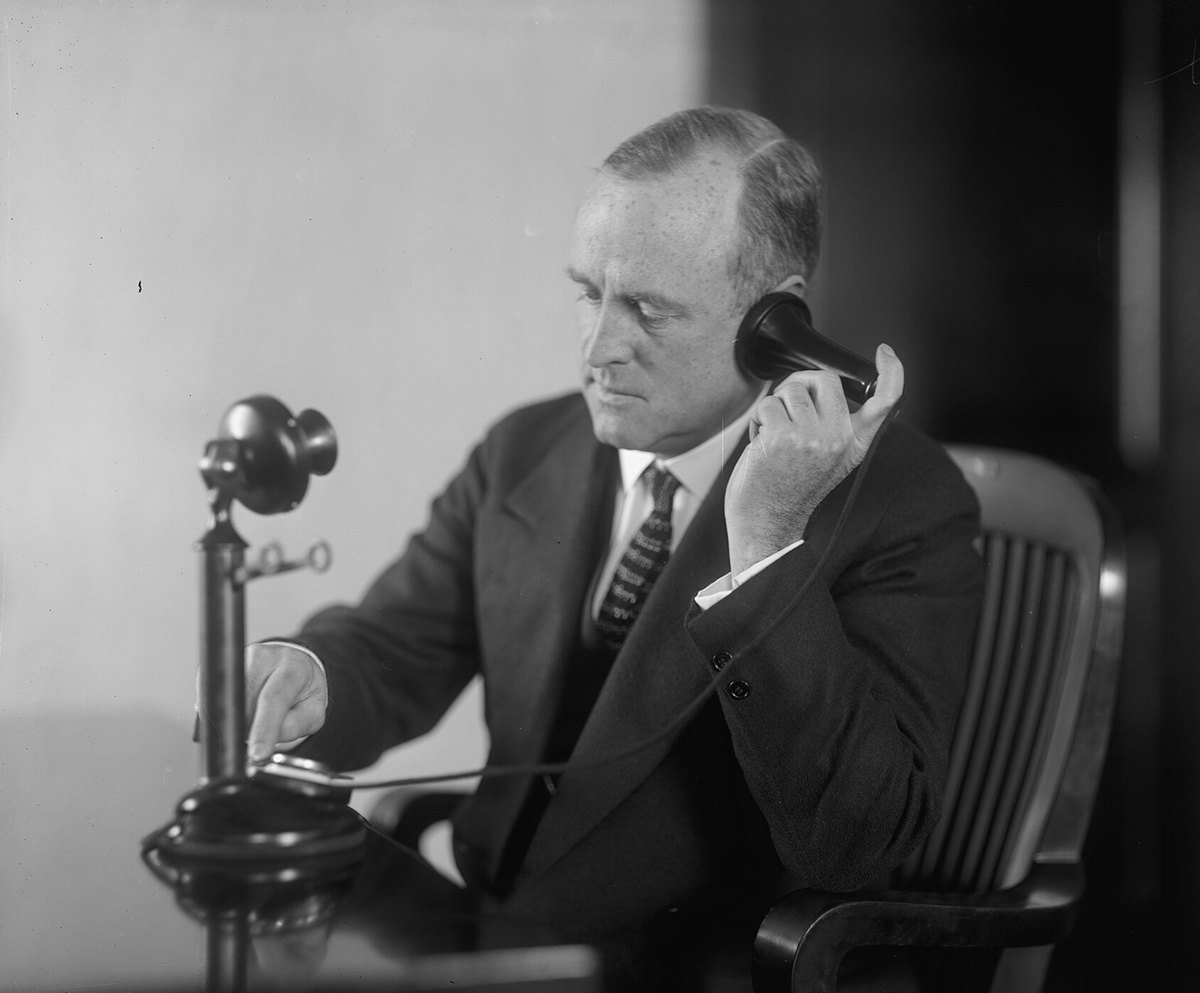 Man listening on a candlestick telephone, Harris and Ewing photograph from the Library of Congress