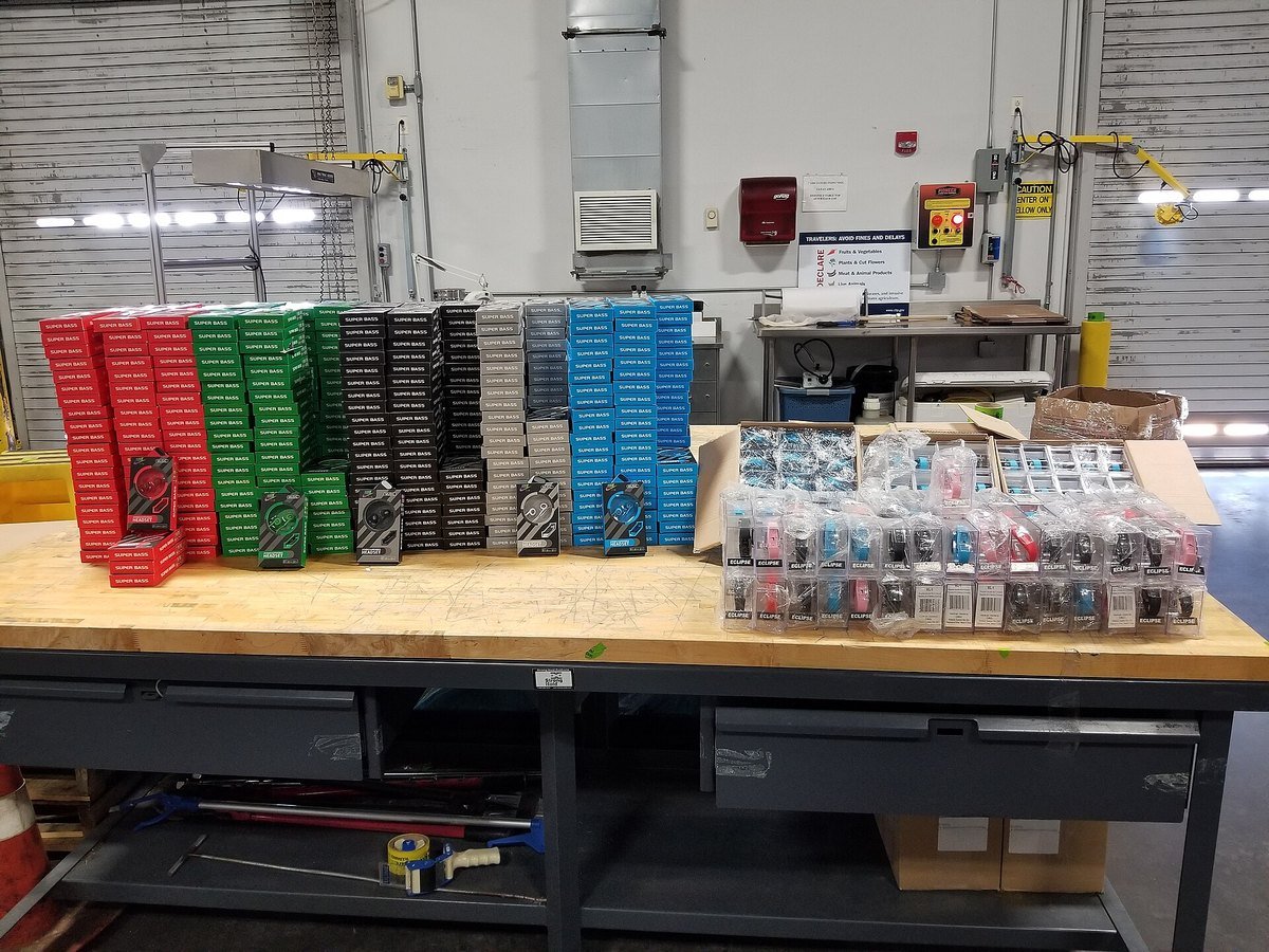 Counterfeit consumer electronics laid out on an inspection table at a U.S. port of entry