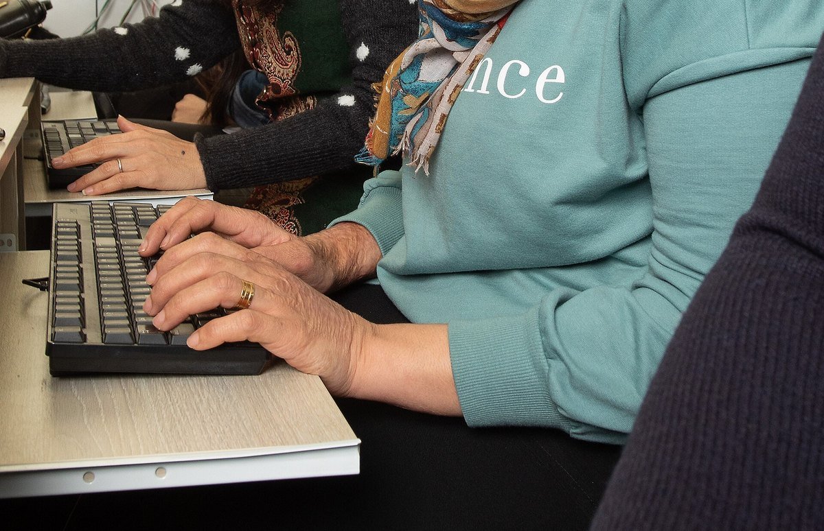 Two data annotators working side by side at keyboards on a shared desk