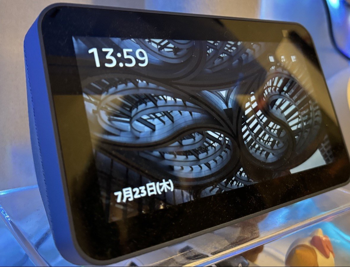 An Echo Show 5 second generation showing only a clock and a photo background