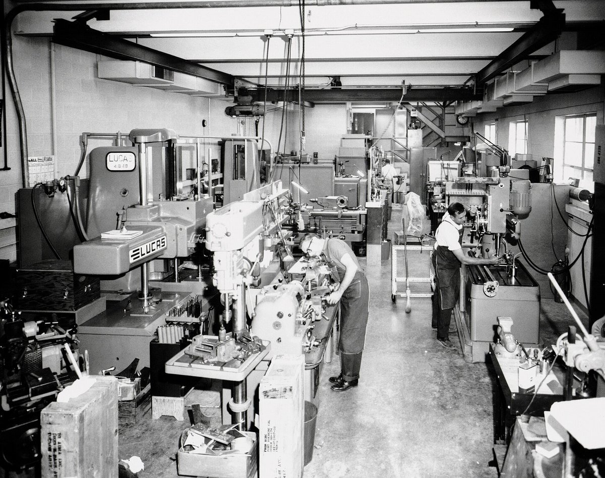 Machinists working at lathes and milling machines in the machine shop of Kitt Peak National Observatory
