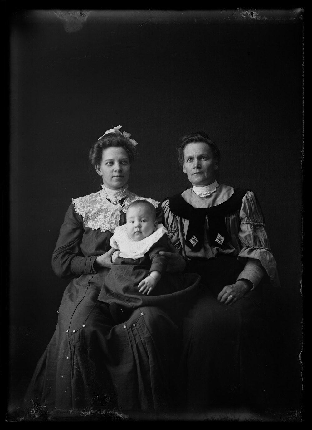A studio portrait of a grandmother, a mother and a baby, around 1900