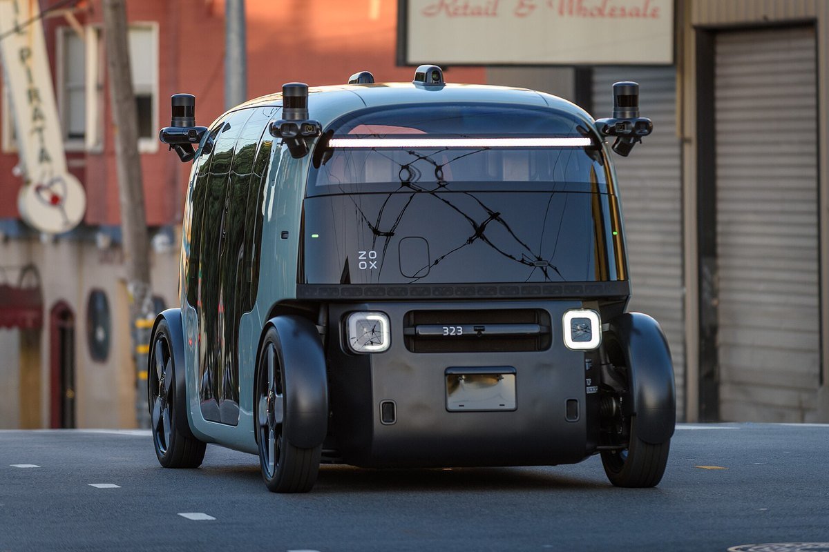 A Zoox purpose-built autonomous robotaxi with roof-mounted sensors and no driver position