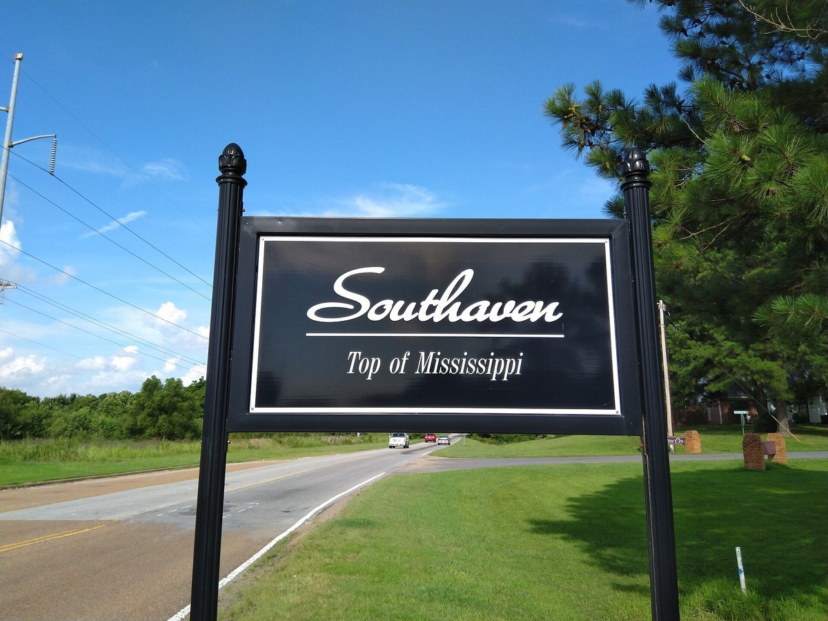 Roadside sign reading Southaven, Top of Mississippi, on a two-lane road under a blue sky