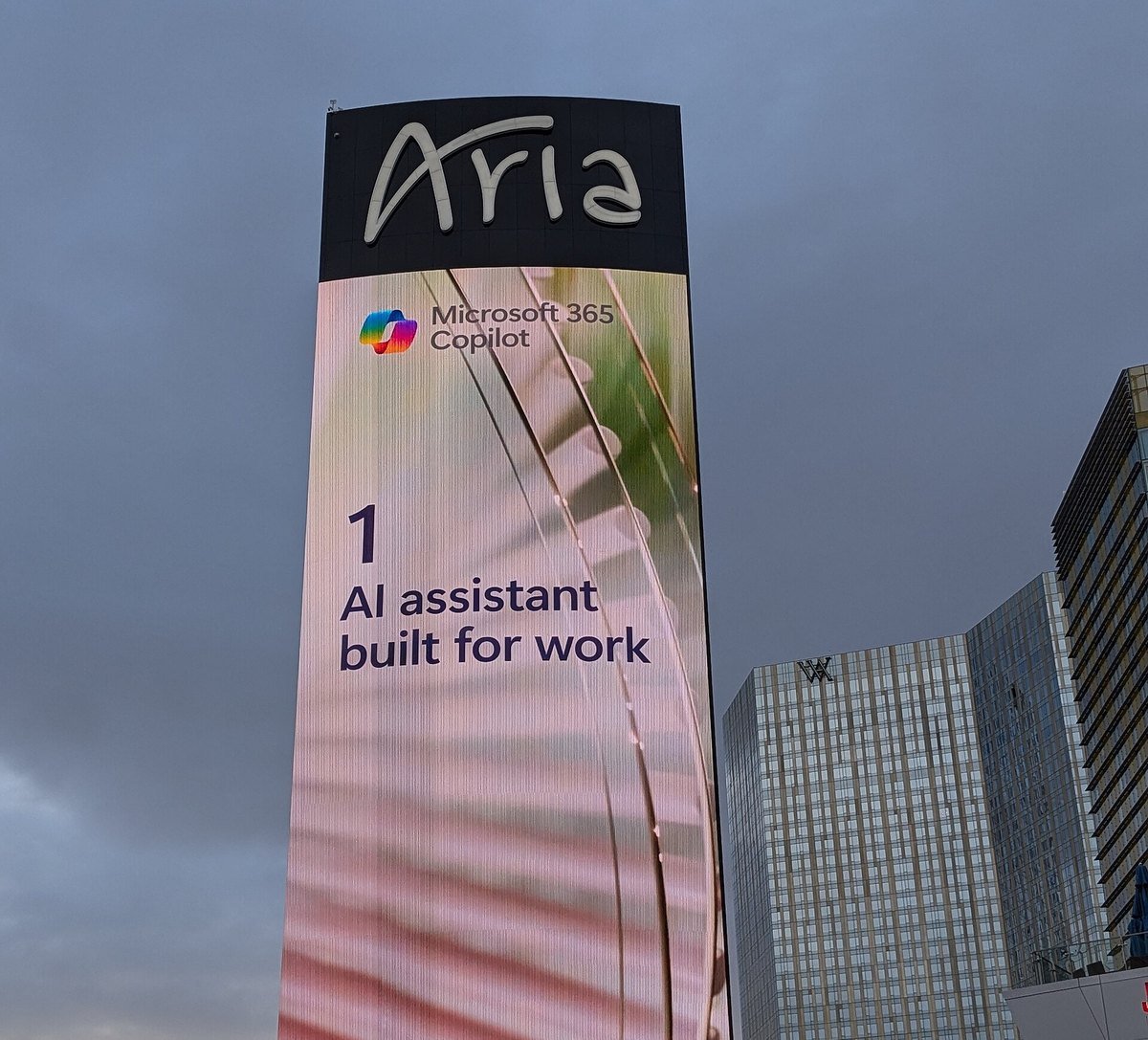 A tall digital billboard in Las Vegas advertising Microsoft 365 Copilot with the line 1 AI assistant built for work