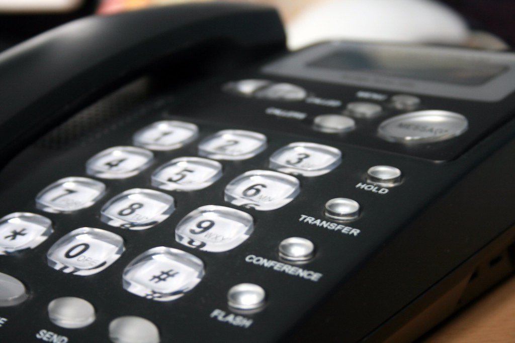 Close-up of a desk telephone keypad with hold, transfer and conference buttons