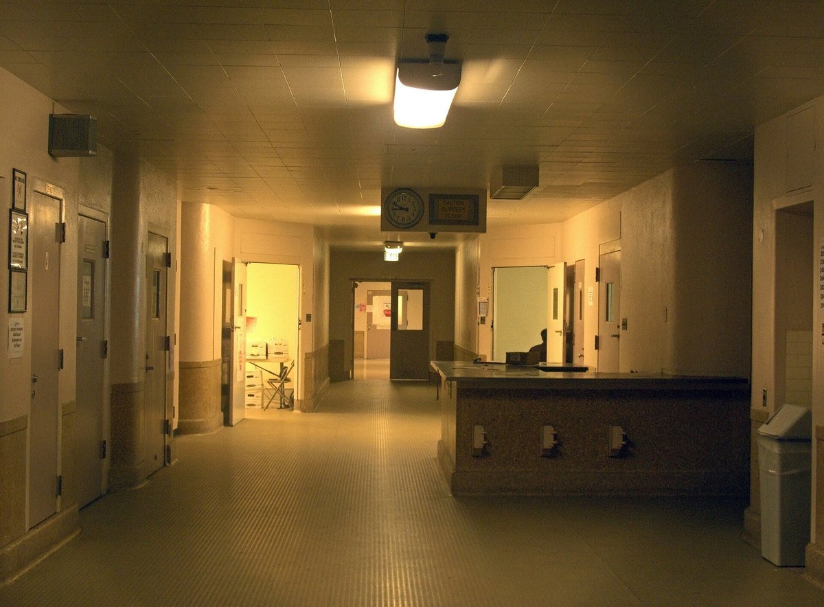 An empty hospital corridor and nurses station at night