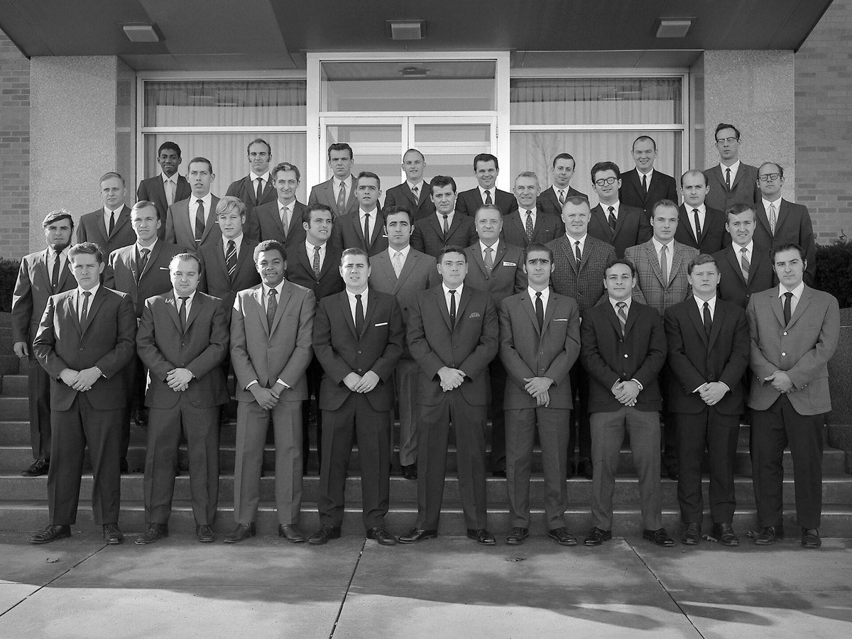 Black and white photograph of about forty men in suits standing in rows on the steps of a NASA building, the 1969 apprentice class graduates.