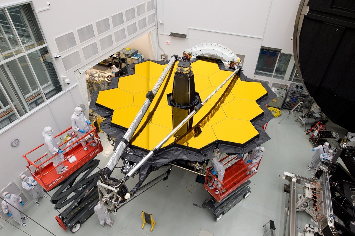 Engineers in cleanroom suits working on the James Webb Space Telescope mirror at NASA's Johnson Space Center