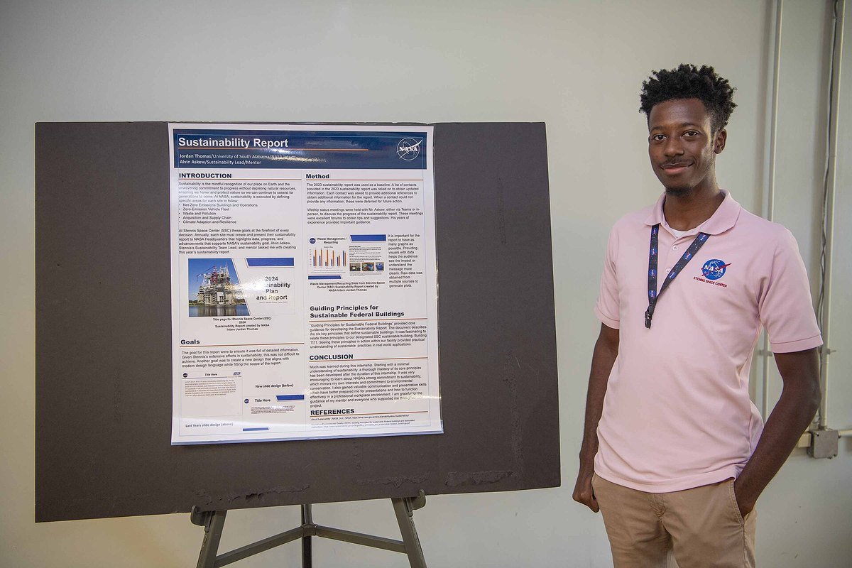 A summer intern stands beside a research poster presenting the work completed during the internship