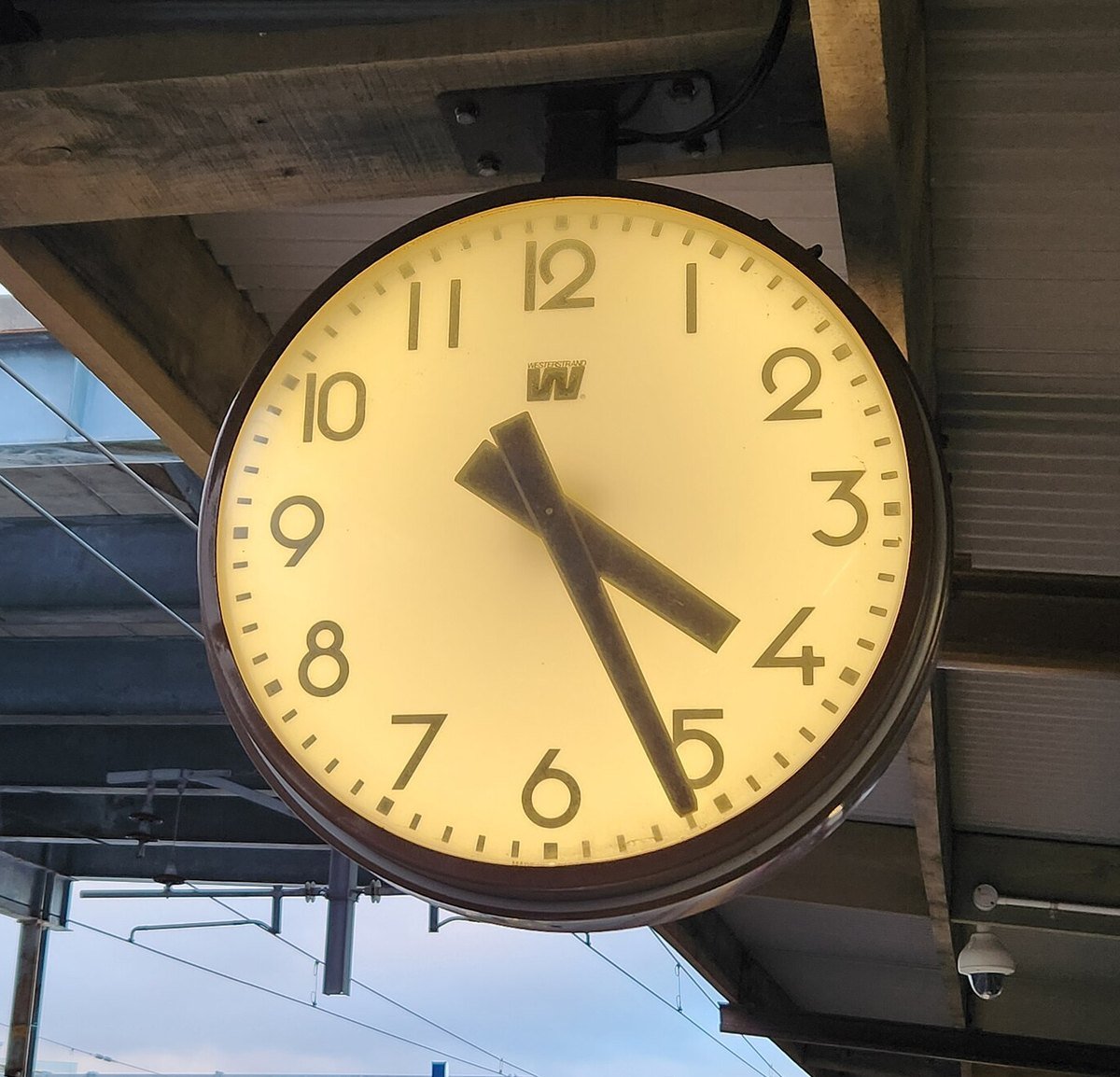 A lit station platform clock showing about twenty past ten.