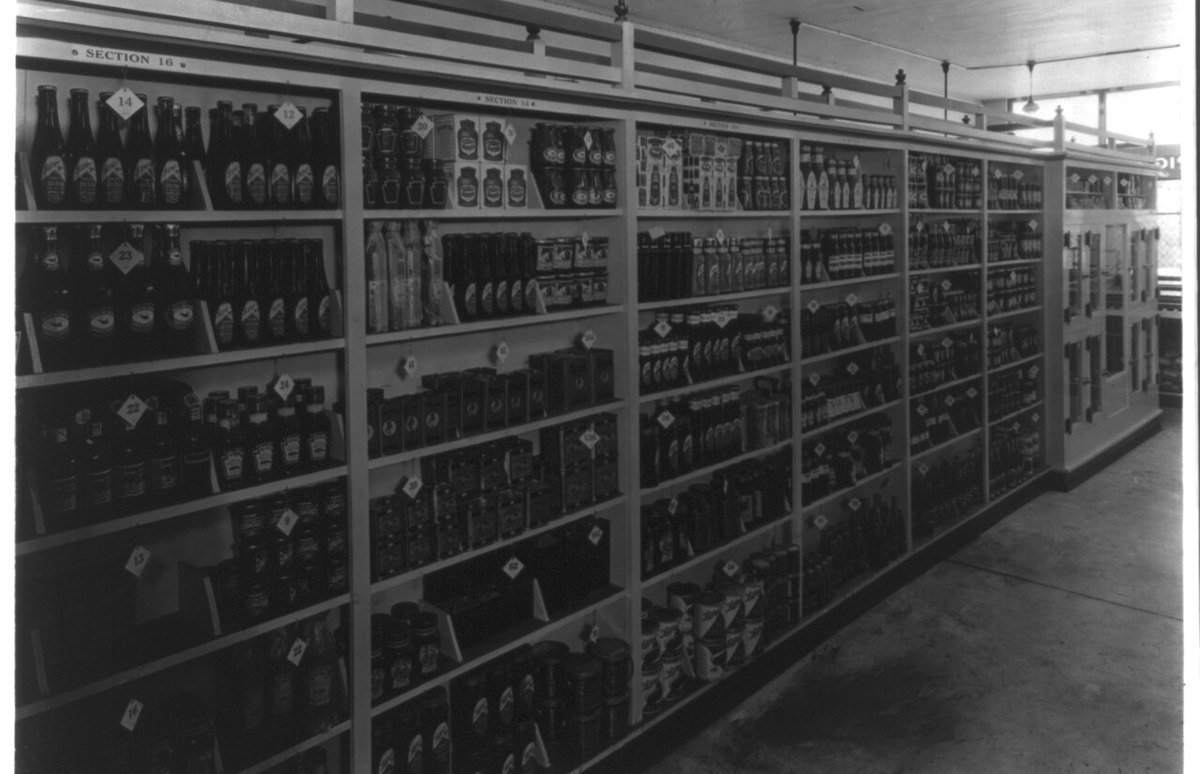 Aisle of a Piggly Wiggly self-service grocery around 1918, with a price tag on every shelf