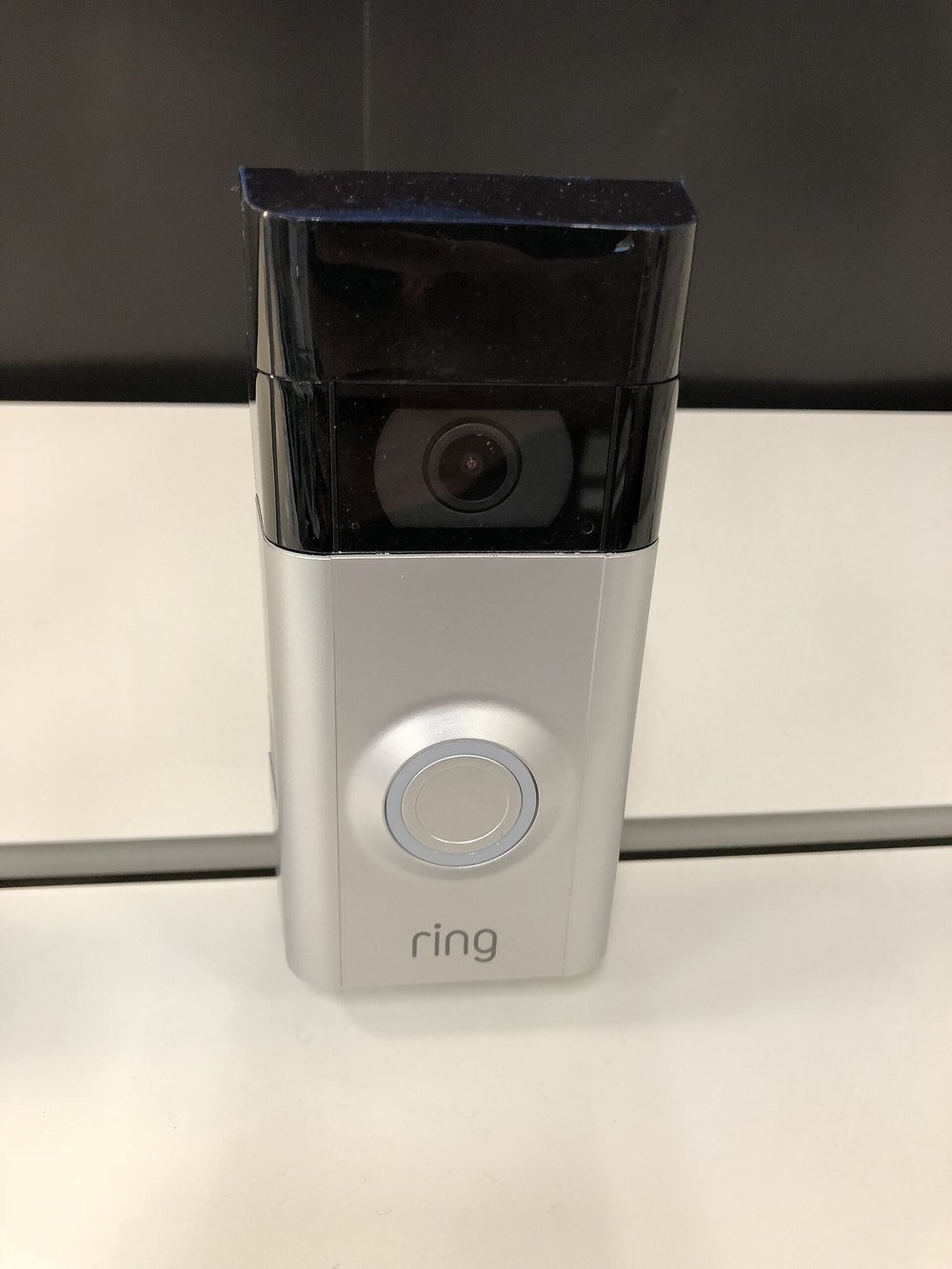 Close view of a Ring video doorbell showing the camera lens and the call button