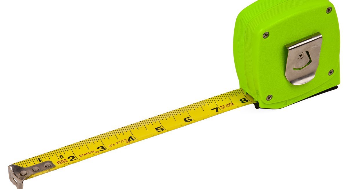 A yellow tape measure with a bright green case, pulled out to about eight inches.