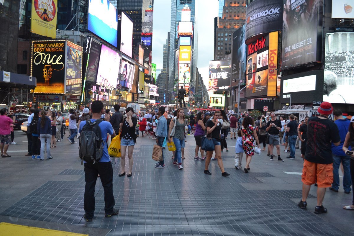 Crowds walking under digital advertising screens in Times Square, New York