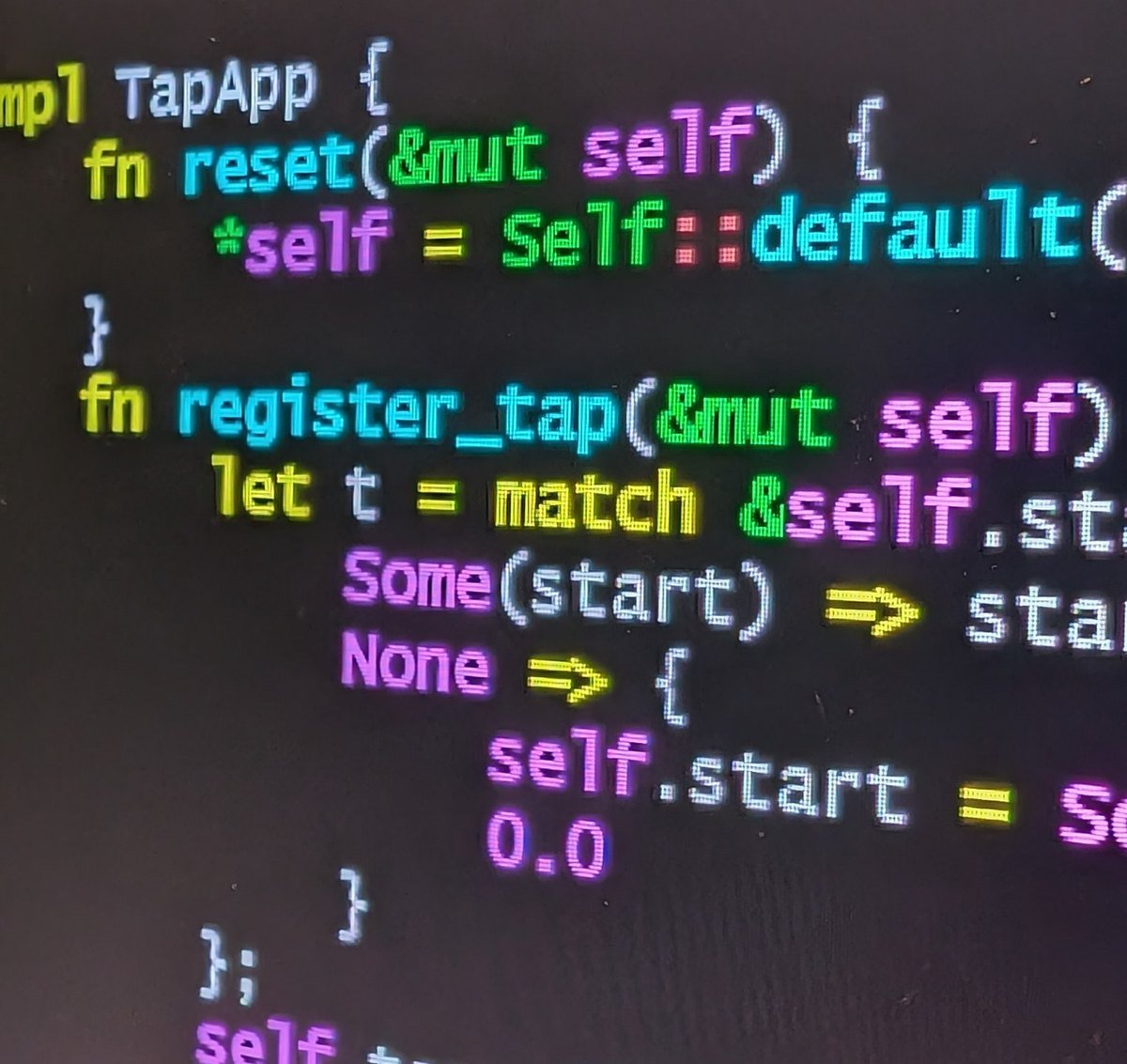 Close-up of colourful program code on a dark computer screen