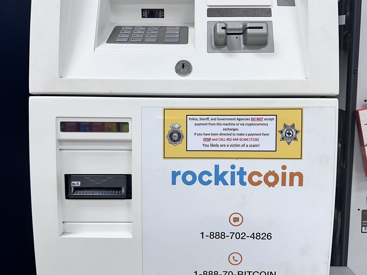 A police warning sticker on a bitcoin ATM saying government agencies do not accept payment from the machine