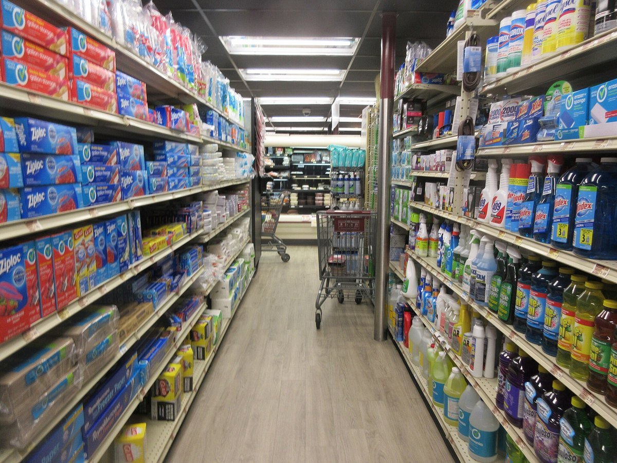 A long grocery store aisle stocked with paper goods and cleaning supplies in New Orleans