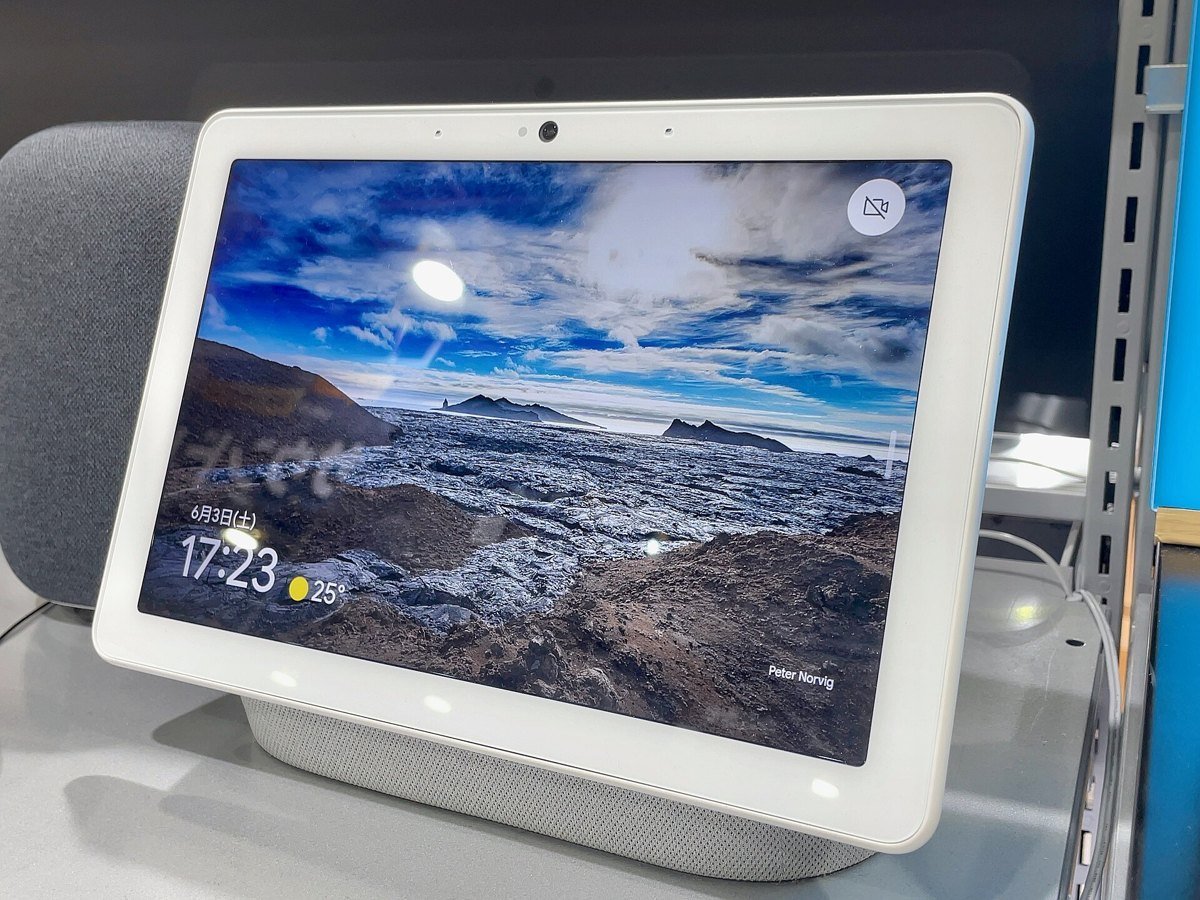 A Google Nest Hub Max smart display on a store shelf showing a landscape photo and the time