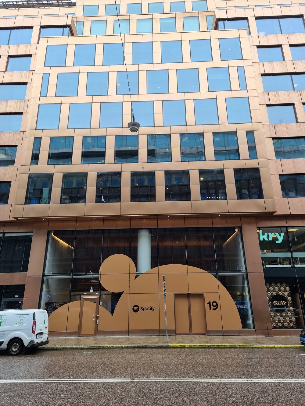 Office building in Stockholm with a large Spotify logo shape at the street-level entrance